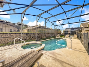A pool area with a hot tub, a wooden deck, and a covered seating area. - Emerald Island 4BR Disney Villa w/ Pool & Games (Kissimmee)