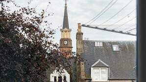 Een kerk met een klokkentoren en een gebouw van steen met een raam.