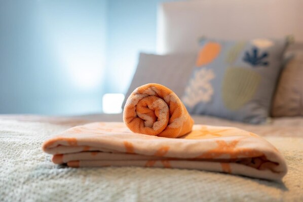 A neatly folded towel on a bed with a patterned blanket. - Beachside Stay - 4 Mins Walk - Free Parking (Stonehaven)