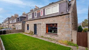 A stone house with a sloped roof, a front door, and a small front yard. - Airport Apartment - Aberdeen - Free Parking (Aberdeen)