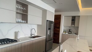 Una cocina moderna con una isla central, electrodomésticos de acero inoxidable y armarios de madera.