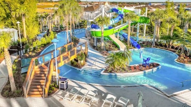 Ein Wasserpark mit Pool, Rutschen und Liegestühlen.