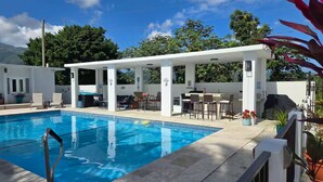 A swimming pool with a covered seating area, outdoor bar, and lounge chairs. - Piscina Vista II Ocean & Mountain Views with Solar (Ceiba)