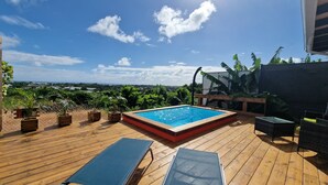 A wooden deck with a swimming pool, lounge chairs, and potted plants. - LE MALIATA "Villa Vue Mer piscine Privée" (Sea View Private Pool) (Saint-François)