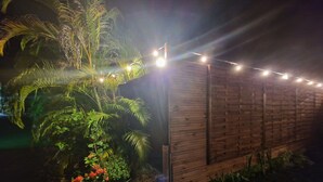 A wooden structure with string lights, surrounded by lush greenery and plants. - LE MALIATA "Villa Vue Mer piscine Privée" (Sea View Private Pool) (Saint-François)