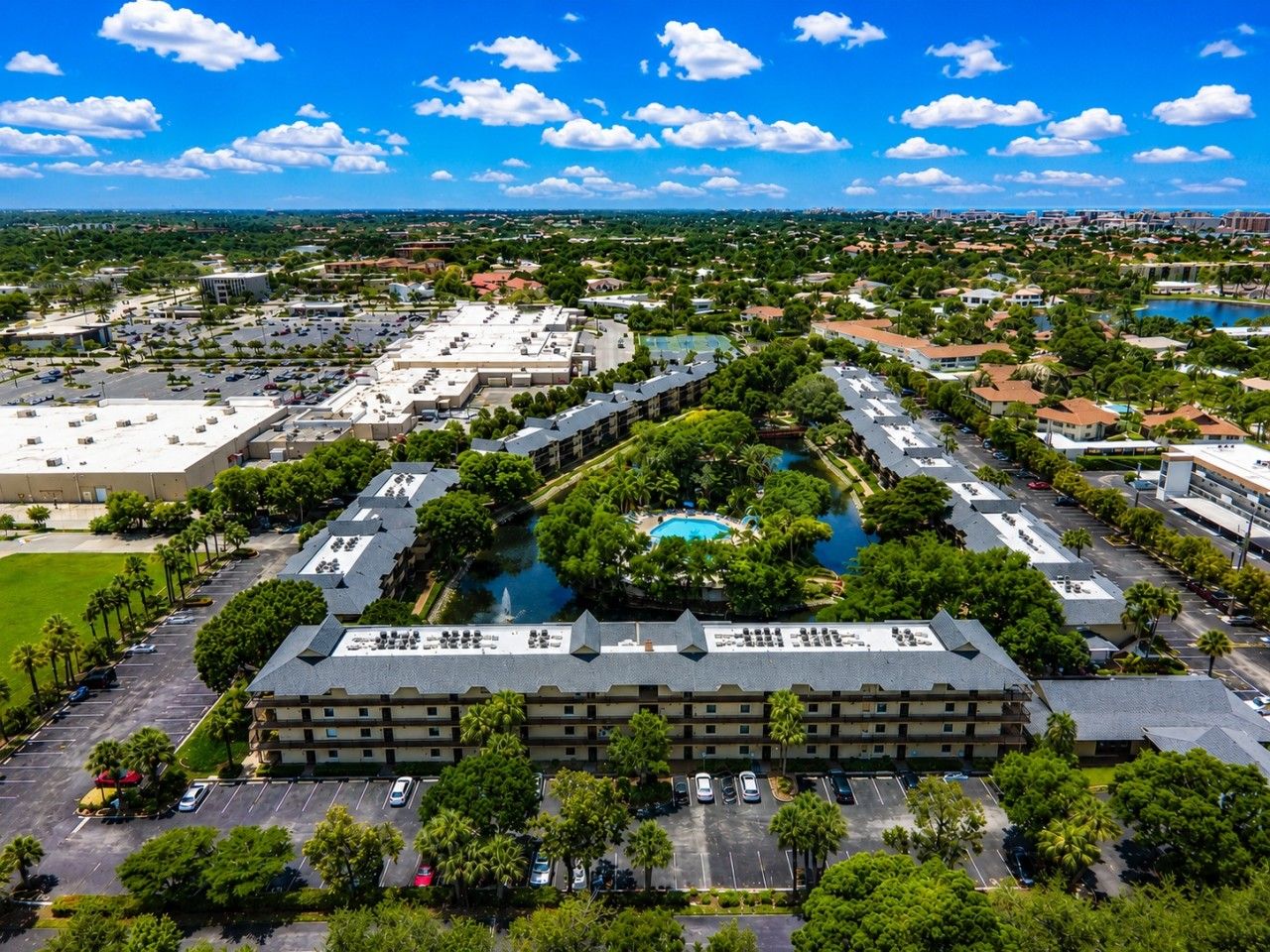 A large hotel complex with multiple buildings, a central swimming pool, and surrounding greenery.
