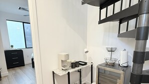 Moderni keittiö, jossa on sisäänrakennettu uuni, pieni työtaso ja portaat, jotka johtavat ylemmälle tasolle.