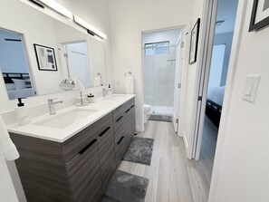 A modern bathroom with two sinks, a large mirror, and a walk-in shower. - NEW HIGH END LUXURY ARCADIA RETREAT 4BR/4BA PRIVATE ROOFTOP (Phoenix)