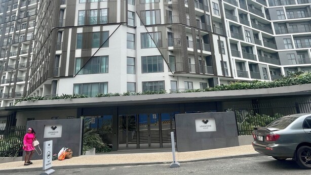 Un moderno edificio de gran altura con un diseño angular distintivo, que cuenta con balcones y amplias ventanas.