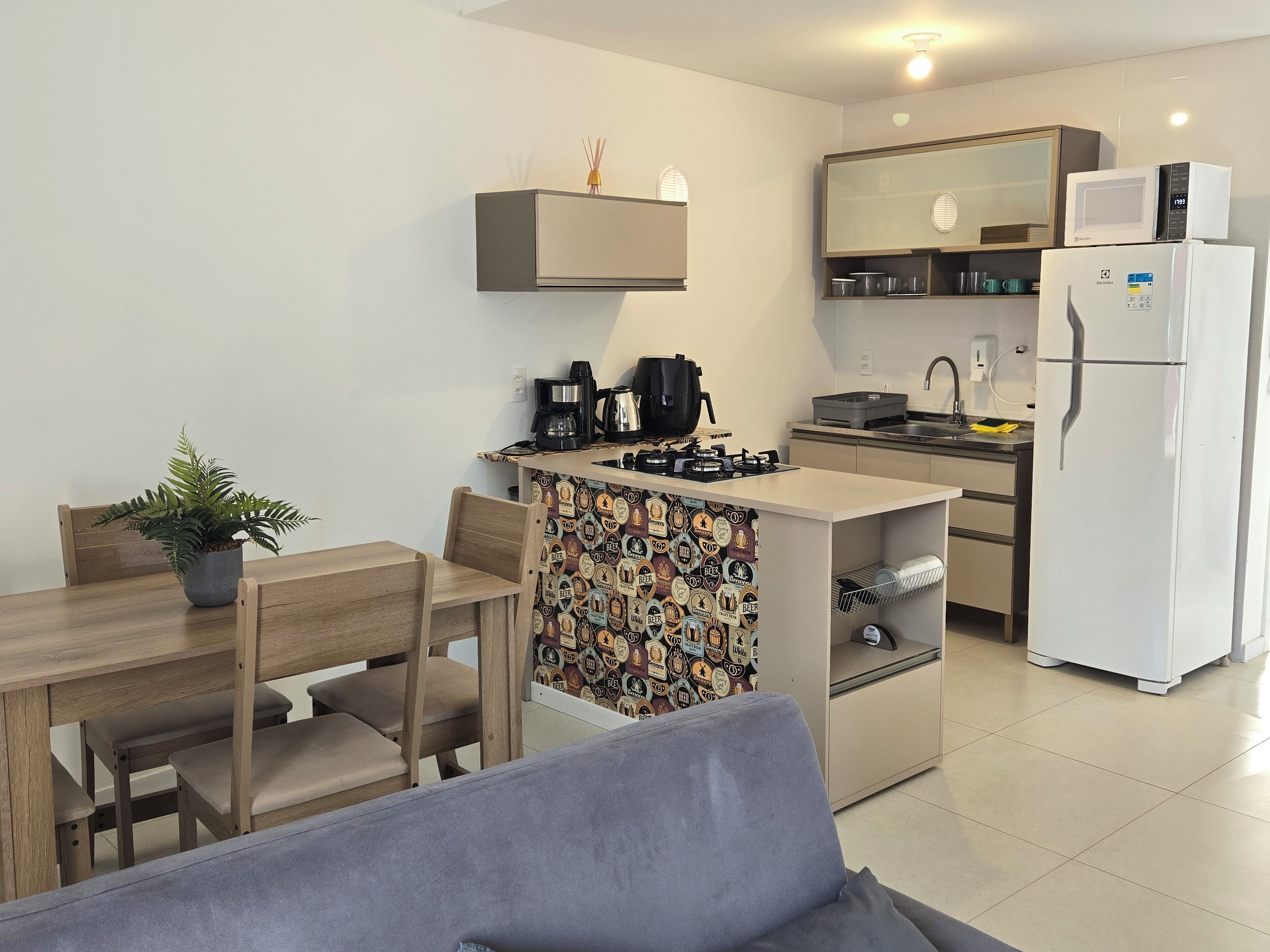 A compact kitchen with a microwave, coffee maker, and a refrigerator.