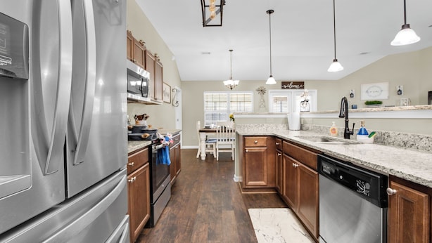 A modern kitchen with stainless steel appliances, wooden cabinets, and a granite countertop. - Game Room - Wind Creek Casino- RTJ Golf - 3 Beds - 2 Bath (Wetumpka)