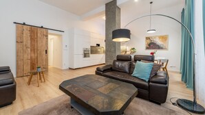 Een moderne woonkamer met een hoekbank, een salontafel en een eethoek met een tafel en stoelen.