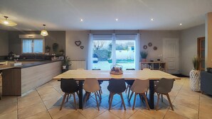 Una cucina moderna con zona pranzo, ampie finestre e vista sull'esterno.