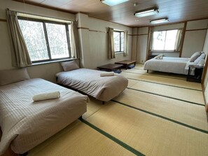 Habitación de hotel con dos camas, una mesita y una ventana.