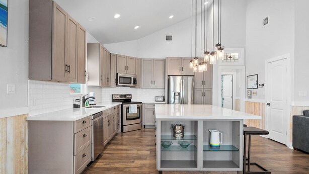 Une cuisine moderne avec des meubles en bois, des appareils en acier inoxydable et un îlot central.