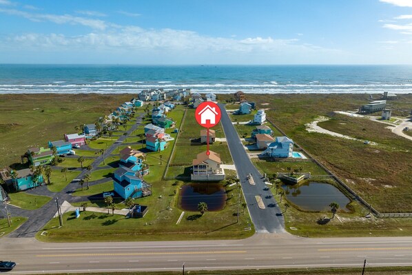 An aerial view of a coastal residential area with houses, a road, and a beach. - Beachview 158! Boardwalk to the Beach! (Port Aransas)