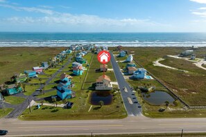 An aerial view of a coastal residential area with houses, a road, and a beach. - Beachview 158! Boardwalk to the Beach! (Port Aransas)