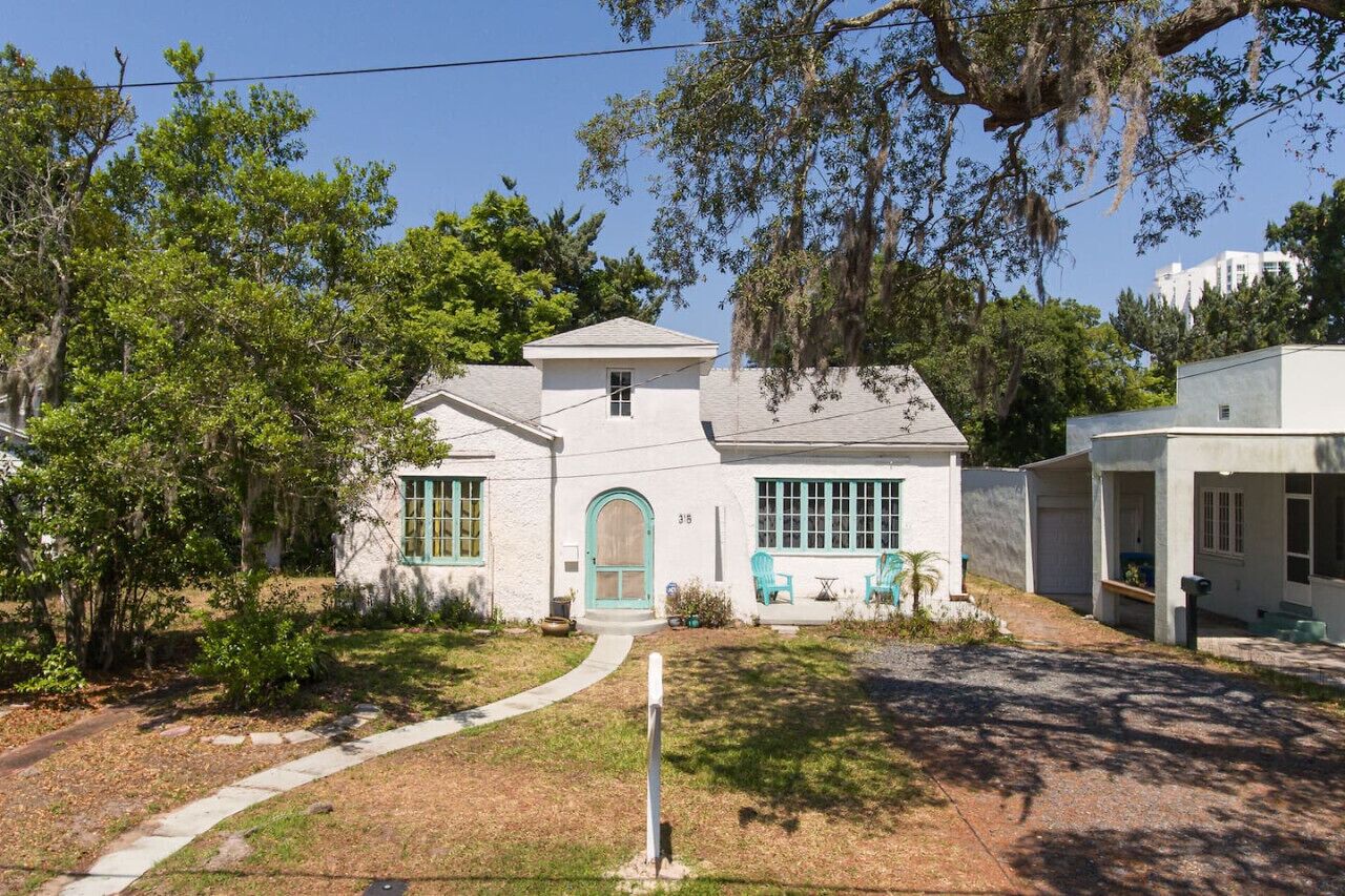 A single-story house with a front porch, a small attached garage, and a well-maintained lawn.