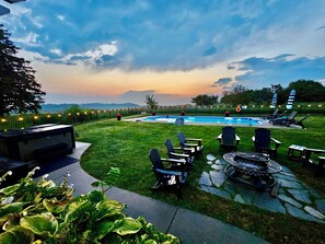 Un giardino sul retro con piscina, area relax all'aperto e vista sul cielo.