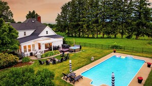 Une maison avec une piscine, du mobilier d’extérieur et un espace patio.