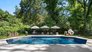 Una piscina al aire libre de temporada, sombrillas