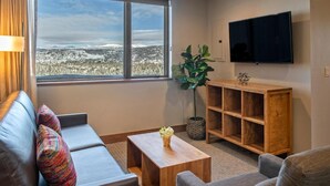 Ein Wohnzimmer mit einer Couch, einem Couchtisch, einem Fernseher und einem Bücherregal.