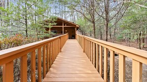 Eine Holzterrasse, die zu einer Hütte im Wald führt.