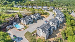 Zona residencial com casas modernas, uma piscina e uma paisagem montanhosa ao fundo.