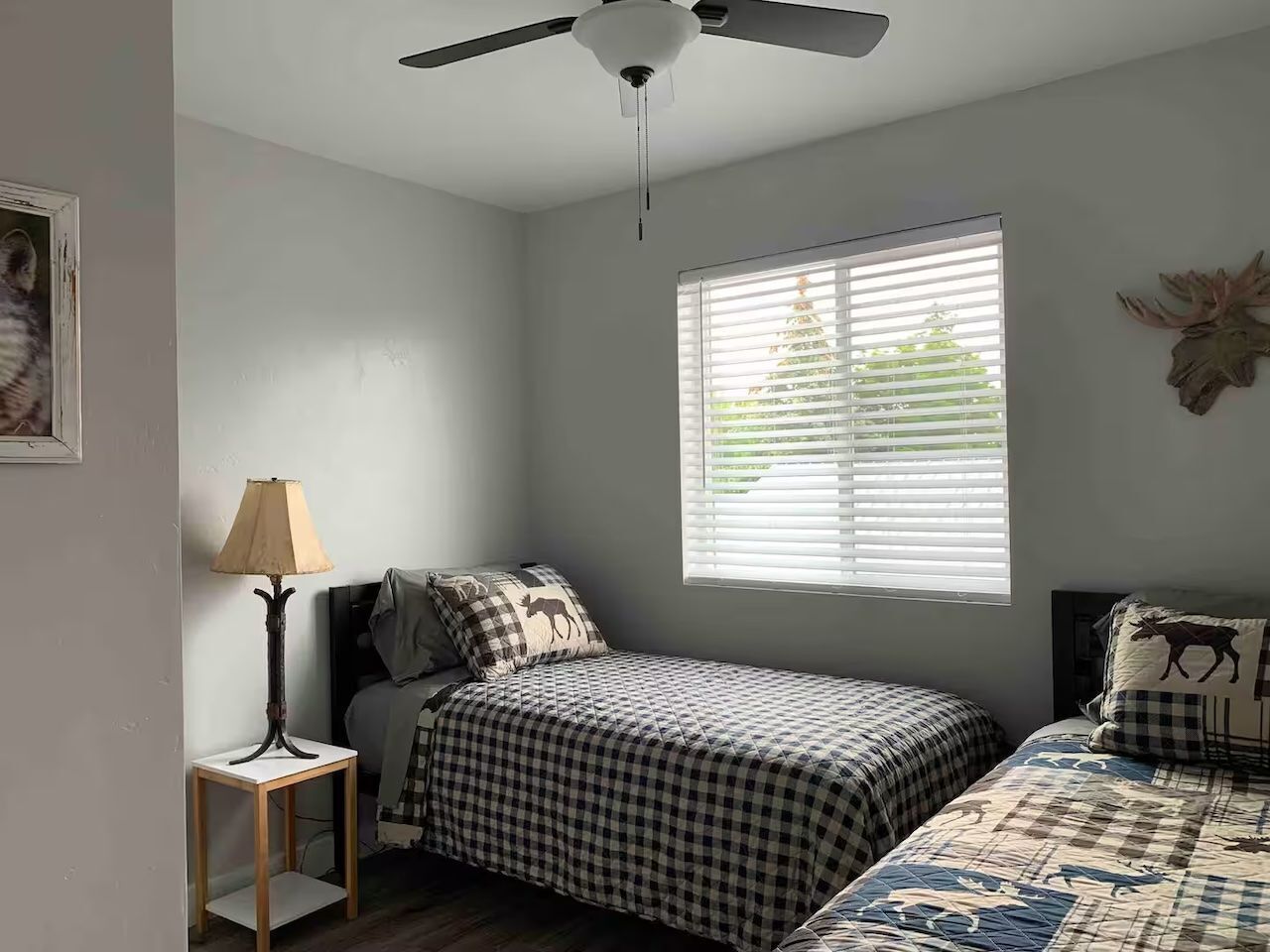 Bedroom with two twin beds, rustic plaid bedding, and a window.