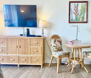 A room with a TV, a lamp, a chair, a table, and a cabinet. - Stylish Studio- Stunning City View - Parking (Honolulu)