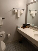 Bañera con ducha, toallas, jabón, shampoo