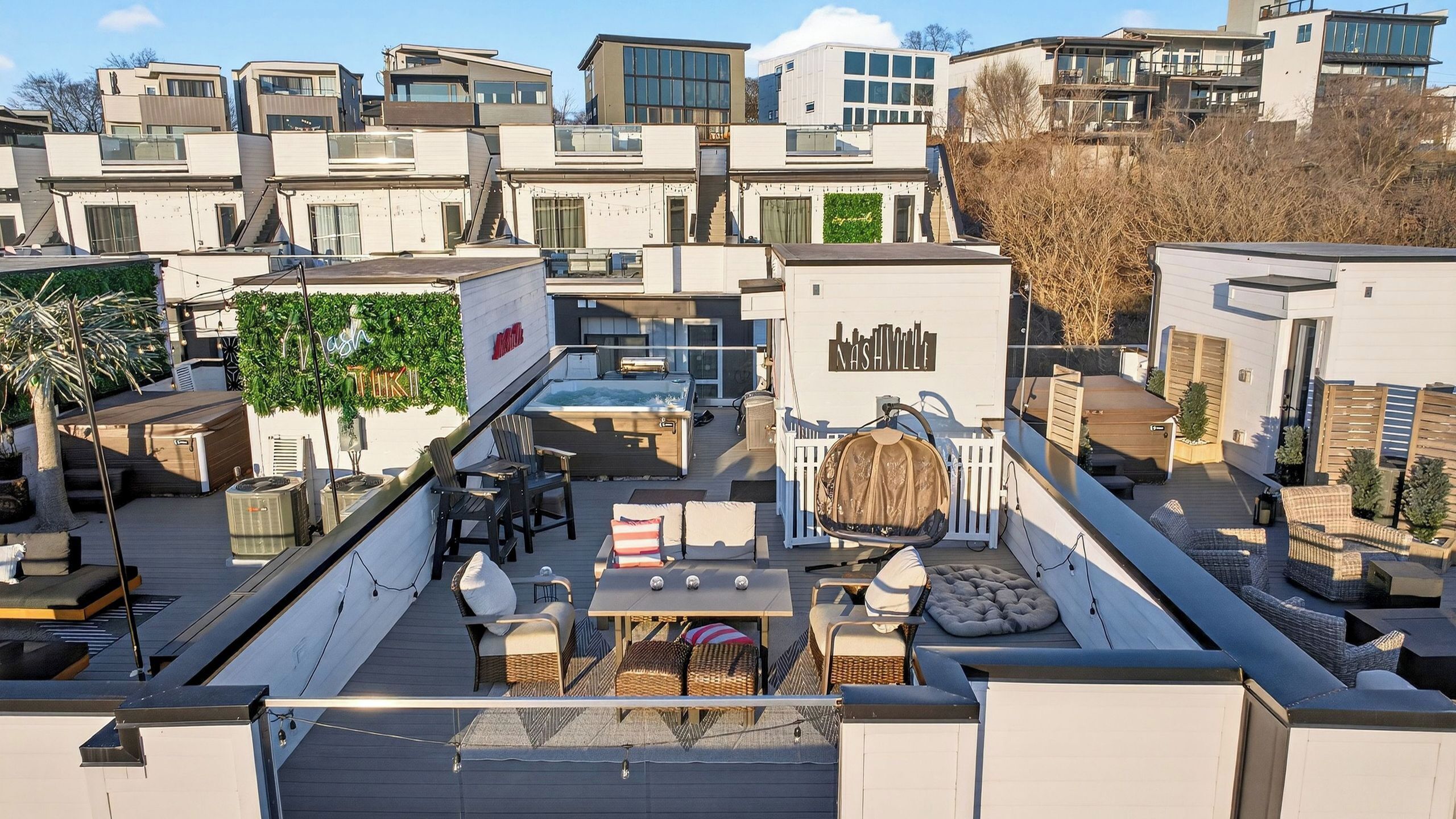 Une terrasse sur le toit avec des sièges en plein air, une piscine et une vue sur des bâtiments modernes.