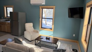A modern living space with a kitchen, a dining area, and a seating area. - Secluded cabin on the trails- cabin #1 (Petoskey)