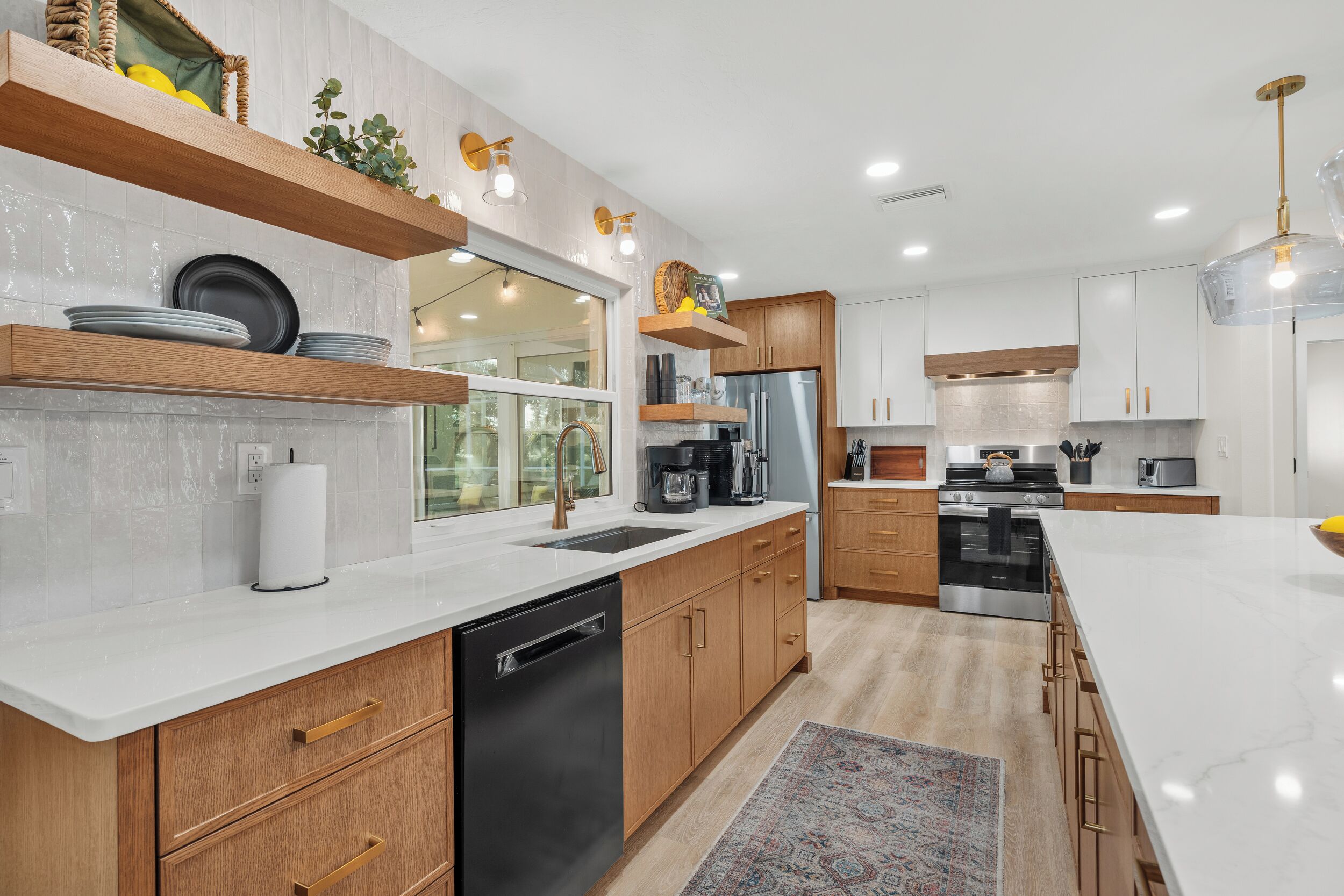 Una cocina moderna con armarios de madera, lavavajillas, refrigerador y una isla grande.