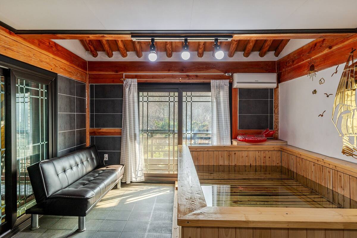 A sauna room with a wooden bench, a bench with a cushion, and a wooden platform.