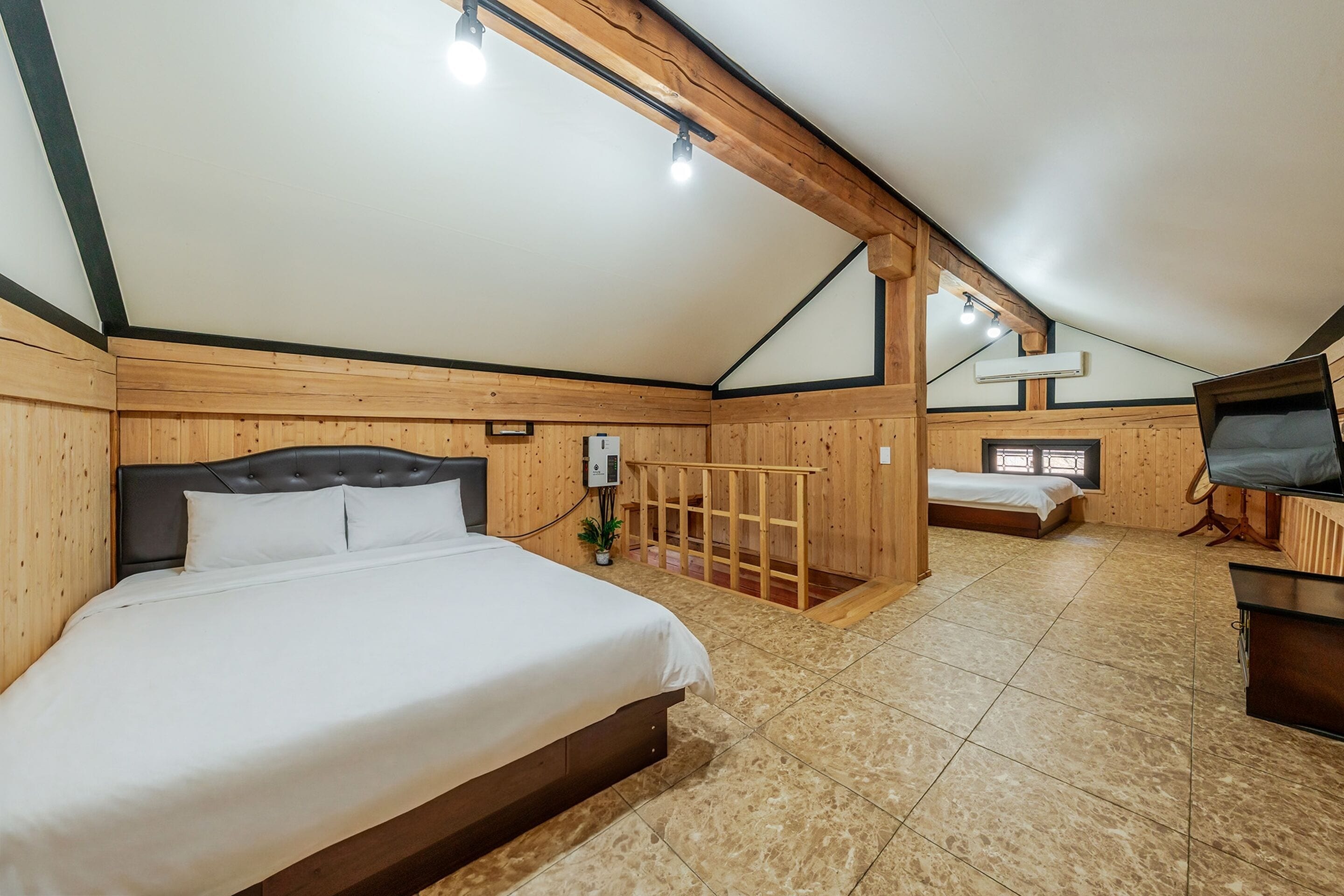 A room with a large bed, a desk, and a small seating area.
