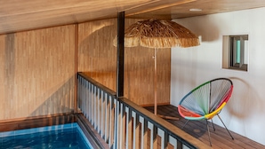 A wooden deck with a pool, a straw umbrella, and a colorful chair. - Gyeongju Palace Hanok Kids Pool Villa (Gyeongju)