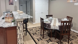 A dining area with a marble countertop, a patterned rug, and a table set for four. - 3-bedroom apartment in Woodbridge close to shopping centers, Quantico and DC. (Woodbridge)