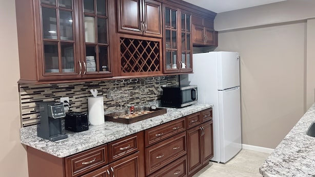 A kitchen with wooden cabinets, a white refrigerator, a microwave, and a coffee maker. - 3-bedroom apartment in Woodbridge close to shopping centers, Quantico and DC. (Woodbridge)