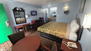 A hotel room with a bed, a desk with a chair, a small table, a telephone, a television, and a mirror. - TRAVEL INN (Richmond)