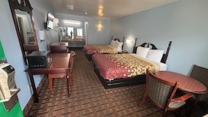 A hotel room with a bed, a desk, a chair, a microwave, and a mirror. - TRAVEL INN (Richmond)
