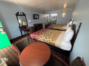 A hotel room with a bed, a desk, a chair, a round table, a television, and a mirror. - TRAVEL INN (Richmond)