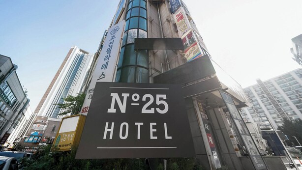 Une enseigne d’hôtel avec l’inscription « HÔTEL N° 25 » bien visible.