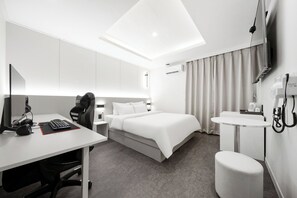 A modern hotel room with a bed, desk, chair, and a small table with a sink. - Bucheon Songnae Number 25  (Bucheon)