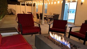 An outdoor seating area with red chairs and a fire pit. - The Coachella Gem with Spa and Fire-pit sleeps 14 (Coachella)