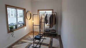 A room with a window, a clothing rack, and a rug. - Vista Mar house & Studio (Ponta Delgada)