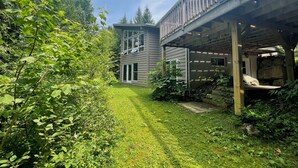 A two-story house with a deck and a covered outdoor area. - Lakefront 5-Bedroom Chalet in Mont-Blanc - Monthly Rental (Laurentians) (Mont-Blanc)