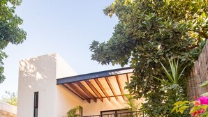 A two-story house with a balcony, a pool, and outdoor seating. - Tropical Paradise in Centro Historico of Merida (Merida)