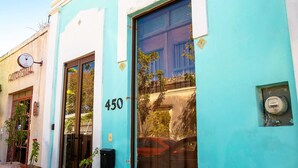 A building with a turquoise facade, a large window, and the number 450 on the wall. - Tropical Paradise in Centro Historico of Merida (Merida)