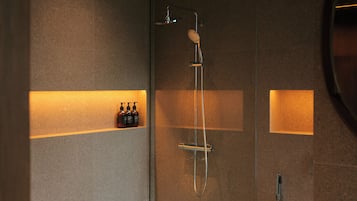 Ducha moderna con cabezal de ducha manual y grifería empotrada.